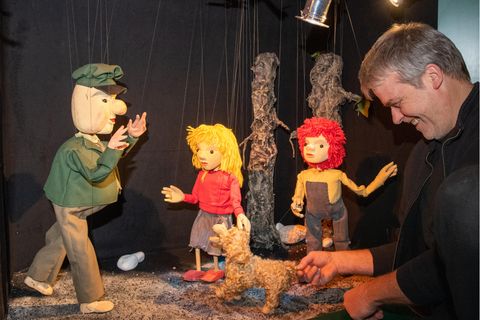 Figuren der Augsburger Puppenkiste mit einem der Puppenspieler