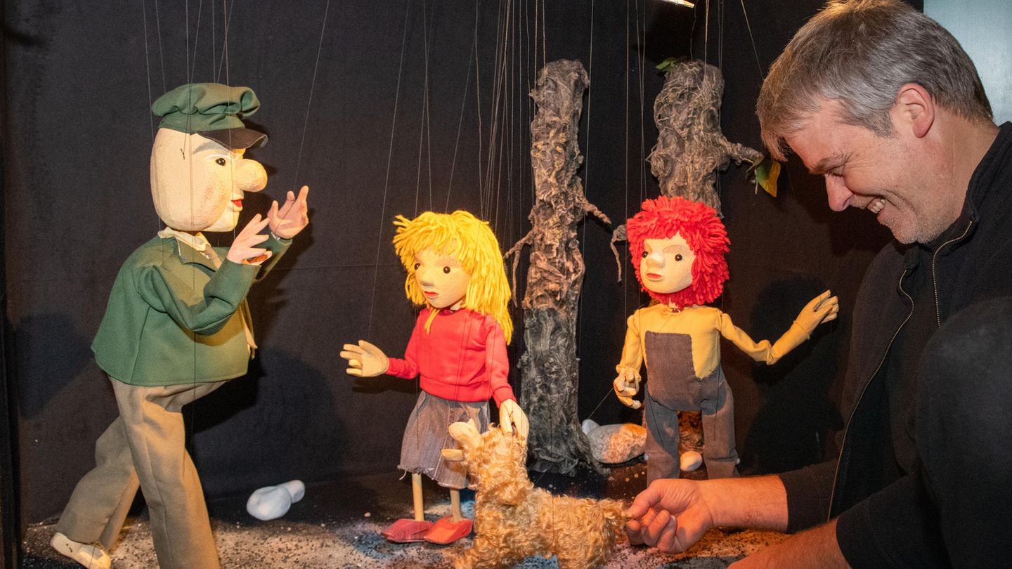 Figuren der Augsburger Puppenkiste mit einem der Puppenspieler