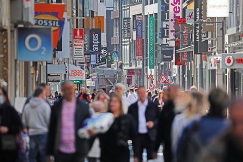 Zahlreiche Menschen gehen über eine Einkaufsstraße