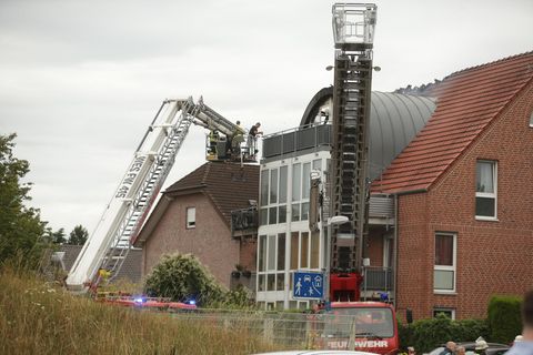 Mit Drehleitern verschaffen sich Einsatzkräfte Zugang zum beschädigten Dachstuhl des Hauses