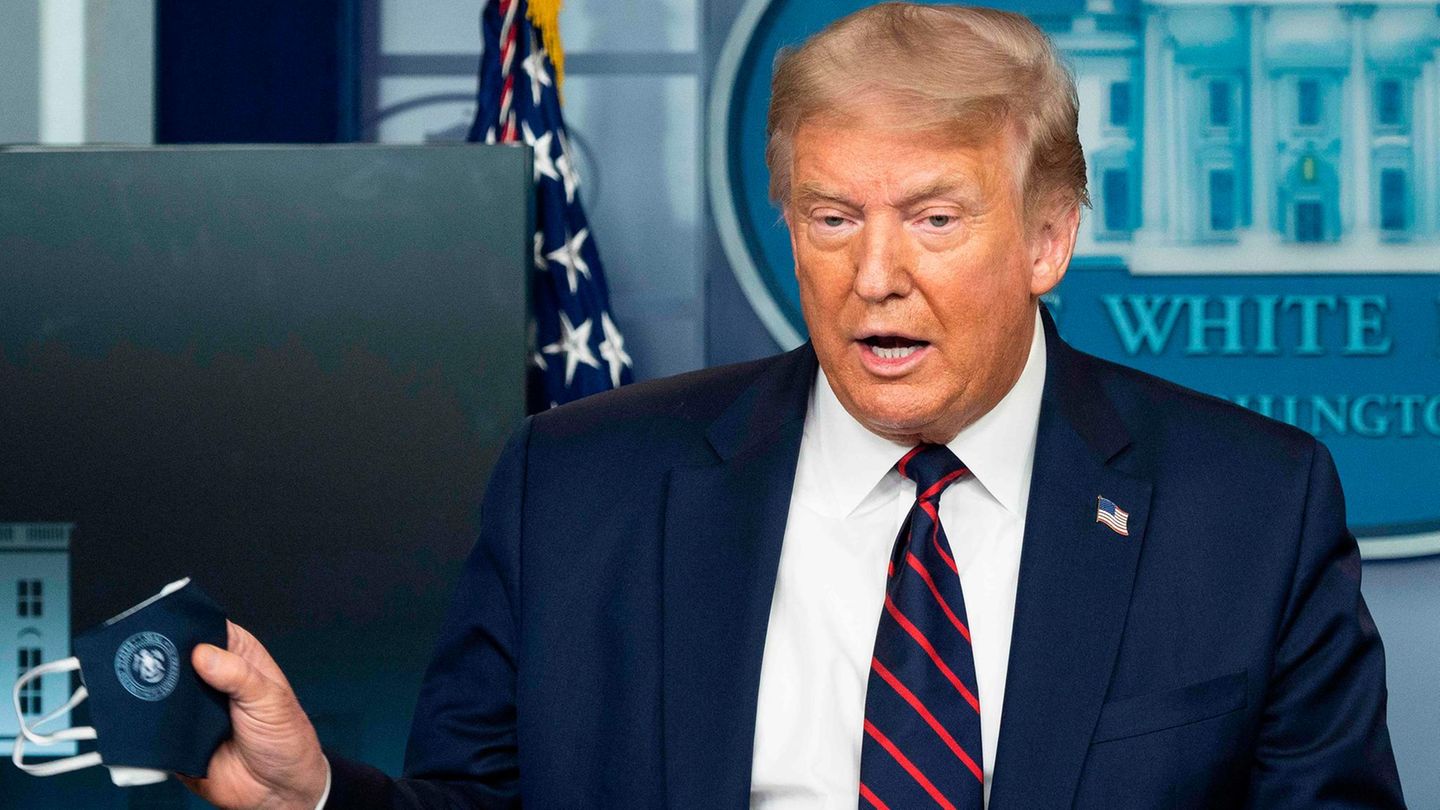 US-Präsident Donald Trump hält bei einem Coronavirus-Briefing einen Mund-Nase-Schutz in die Kameras