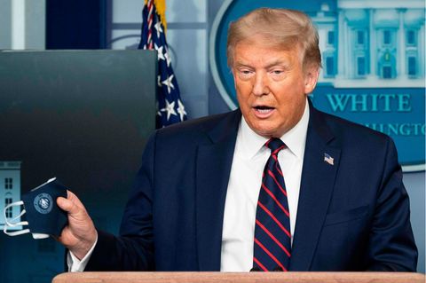 US-Präsident Donald Trump hält bei einem Coronavirus-Briefing einen Mund-Nase-Schutz in die Kameras