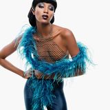 Naomi Campbell in einem Metall-Netzhemd mit Federboa