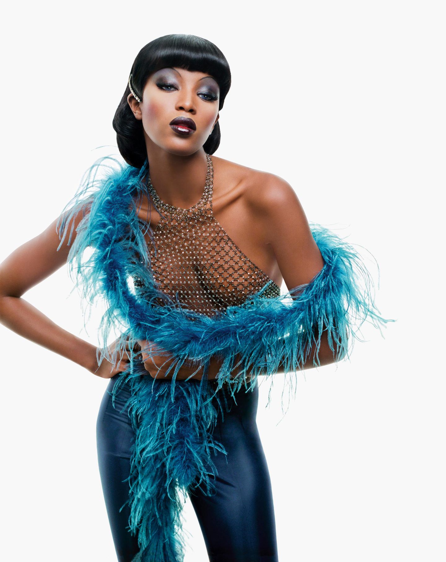 Naomi Campbell in einem Metall-Netzhemd mit Federboa