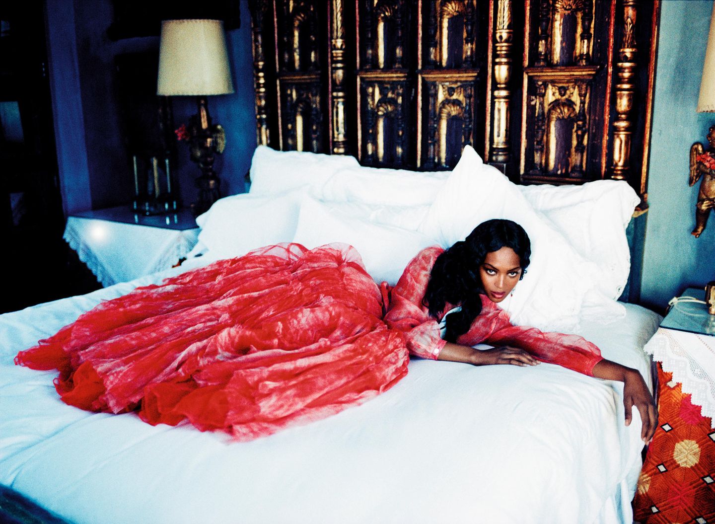 Naomi Campbell liegt im Ballkleid auf einem Hotelbett
