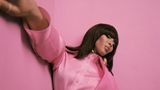Naomi Campbell in Pink vor einer pinkfarbenen Wand