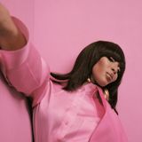 Naomi Campbell in Pink vor einer pinkfarbenen Wand
