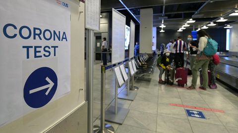 Ein Schild am Flughafen Düsseldorf weist zu einer Corona-Teststelle