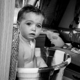 Ein kleines Kind badet in einer Waschschüssel