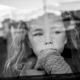 Ein Mädchen schaut verträumt aus dem Fenster