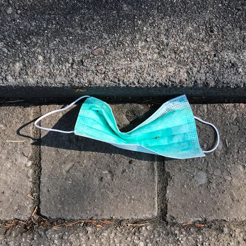 Eine gebrauchte Atemschutzmaske liegt am Straßenrand