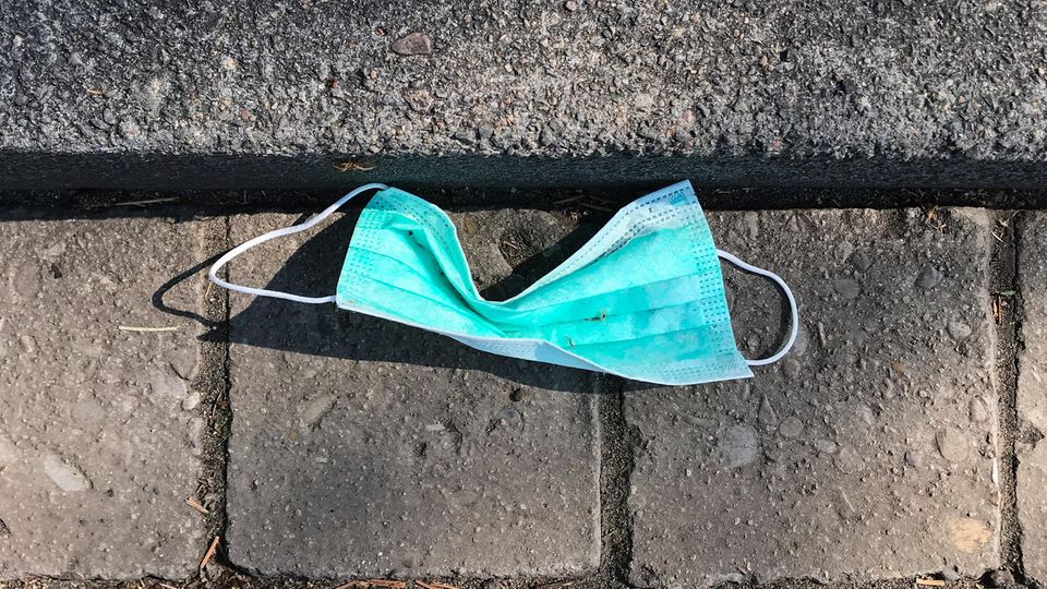 Eine gebrauchte Atemschutzmaske liegt am Straßenrand