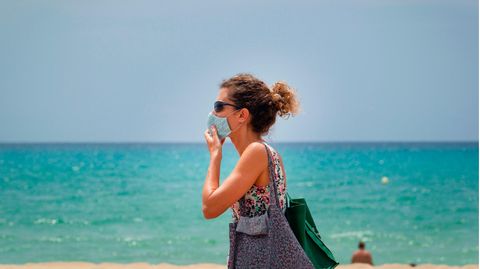 Touristin mit Maske an der Platja de Palma