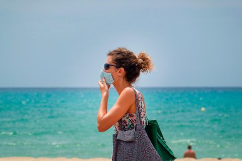 Touristin mit Maske an der Platja de Palma