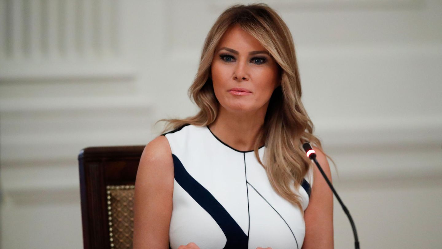 Melania Trump sitzt vor einem Mikrofon an einem Tisch