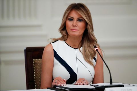 Melania Trump sitzt vor einem Mikrofon an einem Tisch