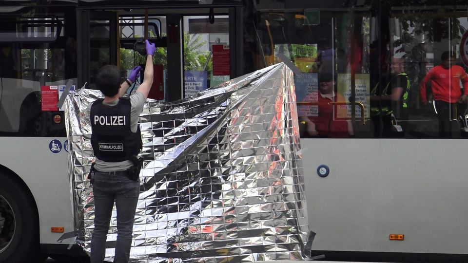 Ein Mitarbeiter der Kriminalpolizei fotografiert den Tatort einer Messerattacke in einem Linienbus.