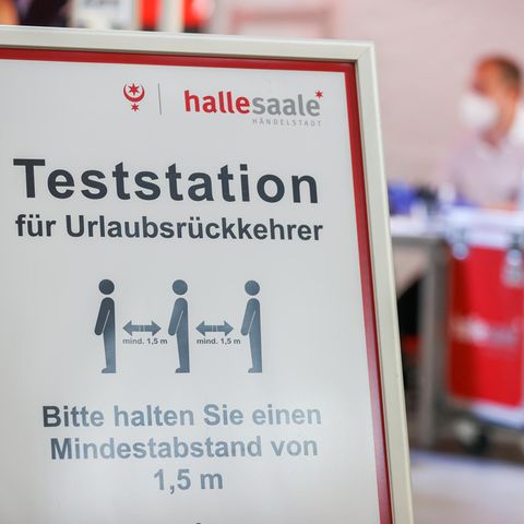 Ein Schild weist den Weg zur Corona-Teststation am Flughafen Leipzig/Halle