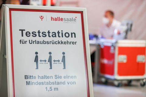 Ein Schild weist den Weg zur Corona-Teststation am Flughafen Leipzig/Halle