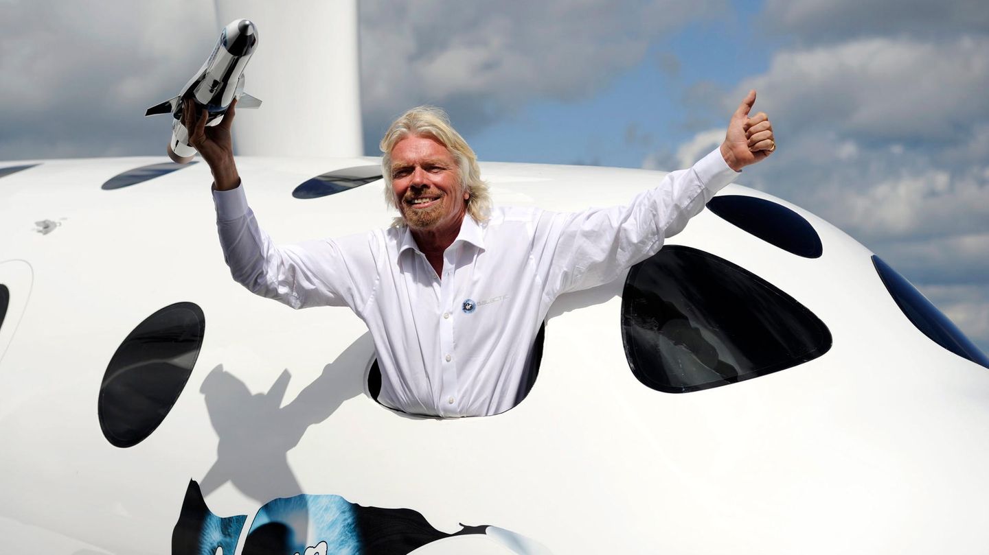 Er rührt vehement die Werbetrommel für sein Projekt: Der britische Geschäftsmann Sir Richard Branson lehnt sich für Fotografen weit aus dem Cockpitfenster.