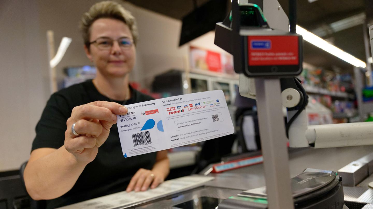 Mitarbeiterin einer Rewe-Filiale in Köln zeigt Knöllchen-Abschnitt mit Barcode