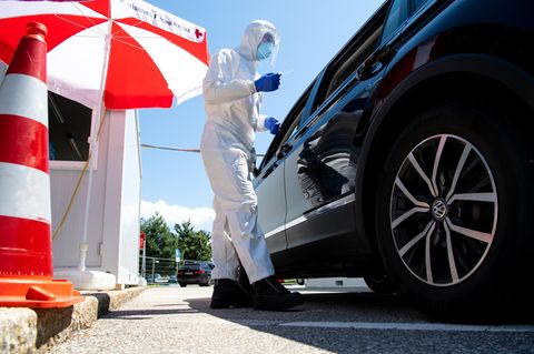 Mitarbeiter vom Bayerischen Roten Kreuz nehmen an einem Corona-Testzentrum einen Abstrich