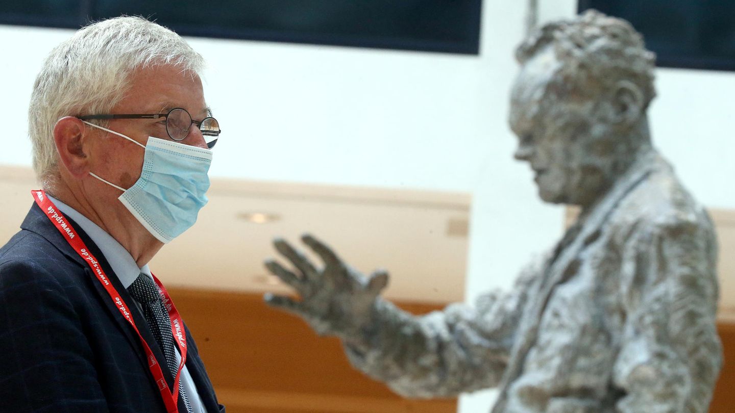 Buchautor Thilo Sarrazin mit Schutzmaske vor der Statue von Willy Brandt in der SPD-Zentrale