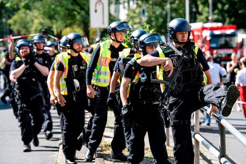 Schwer bewaffnete Polizeibeamte stehen an einem Kaufhaus am Hermannplatz