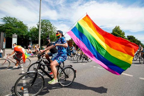 CSD 2020: Ein Demonstrant fährt mit dem Rad und einer Regenbogenfahne durch Hamburg.