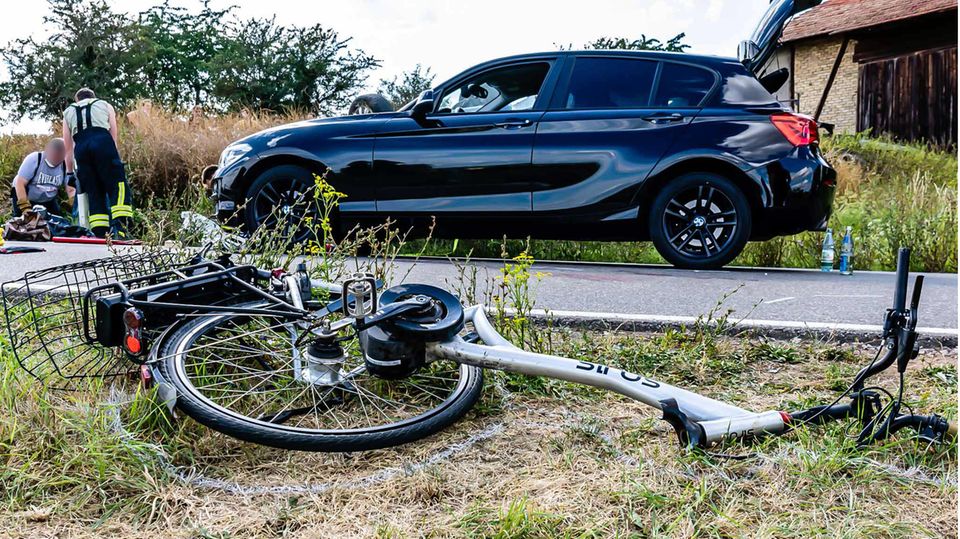 Ein Fahrrad liegt am Seitenstreifen einer Straße.