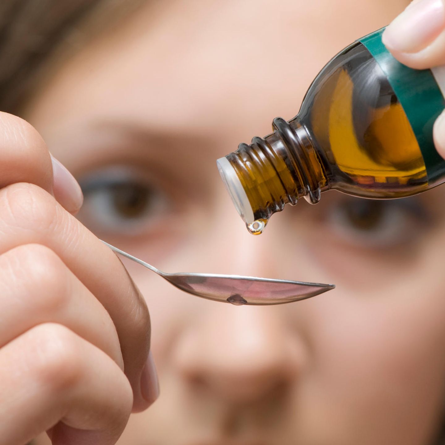 Homöopathie: Eine Frau lässt eine Medikament auf einen Löffel tropfen