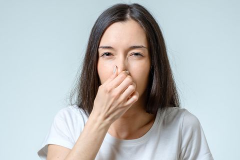 Coronavirus Anosmie: Eine Frau hält sich die Nase zu
