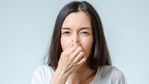 Coronavirus Anosmie: Eine Frau hält sich die Nase zu
