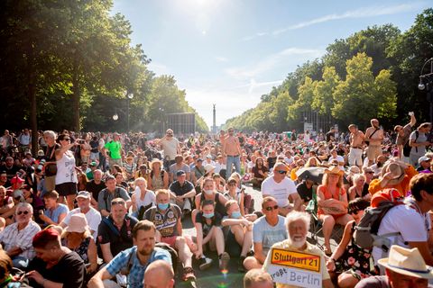 Ein Teilnehmer einer Kundgebung gegen die Corona-Beschränkungen halten sich dicht gedrängt auf der Straße des 17. Juni auf