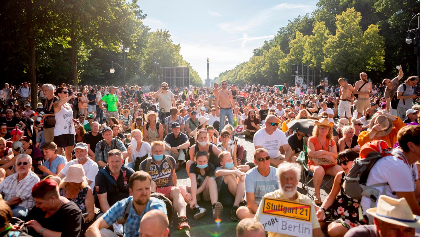 Ein Teilnehmer einer Kundgebung gegen die Corona-Beschränkungen halten sich dicht gedrängt auf der Straße des 17. Juni auf