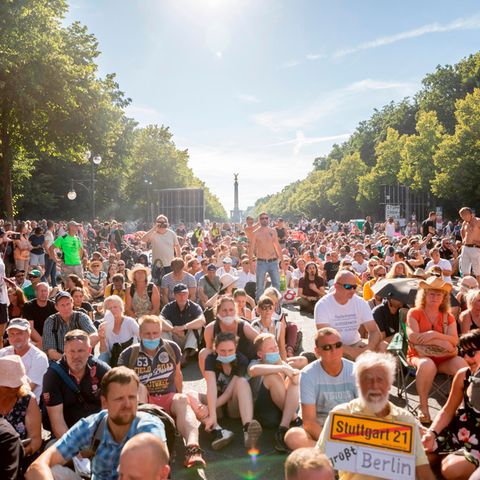 Ein Teilnehmer einer Kundgebung gegen die Corona-Beschränkungen halten sich dicht gedrängt auf der Straße des 17. Juni auf