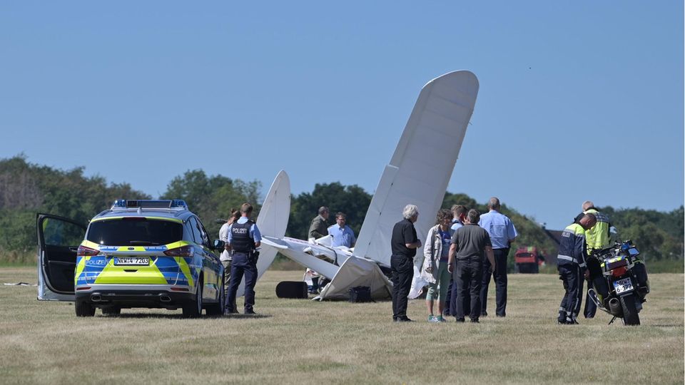 Rettungskräfte stehen am Flughafen Iserlohn-Rheinermark an der Stelle, an der ein Leichtflugzeug abgestürzt ist
