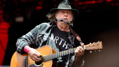 Neil Young mit akustischer Gitarre auf der Bühne