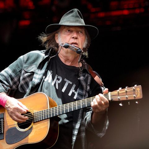 Neil Young mit akustischer Gitarre auf der Bühne