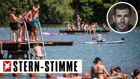 Badegäste genießen das sonnige Wetter an einem See in Baden-Württemberg