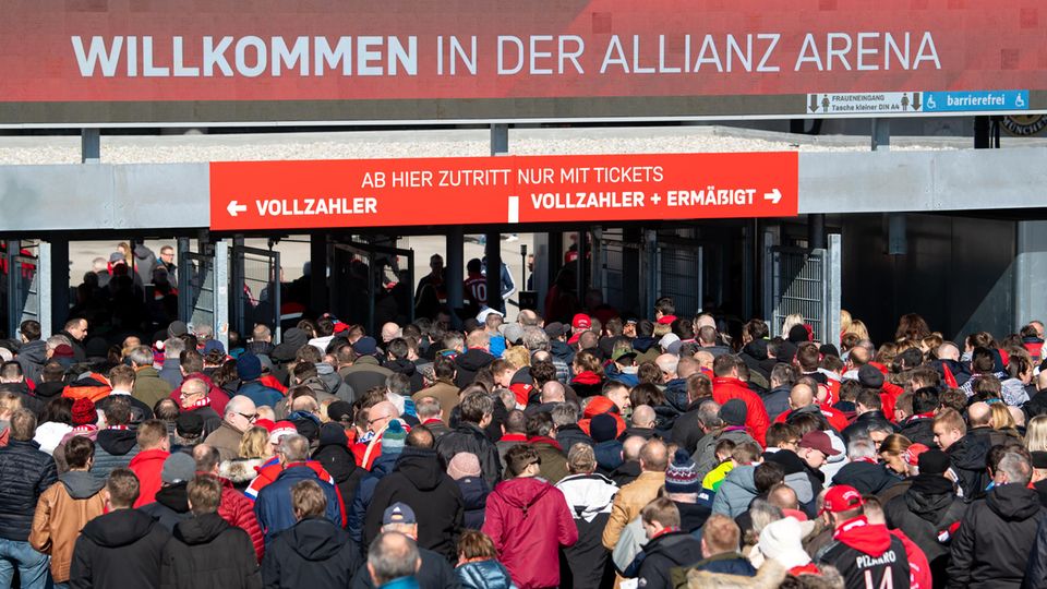 Fußballfans drängeln vor den Eingängen der Allianz Arena in München