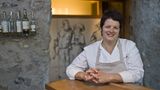 DIE STERNEKÖCHIN  Anna Matscher, 59, ist Südtirols einzige Köchin mit einem Michelin-Stern. Zusammen mit Ehemann und Tochter betreibt sie das Restaurant „Zum Löwen“ in Tisens.  „Ich bin auf einem Bauernhof im Pustertal aufgewachsen, als zweijüngstes von acht Kindern. Mein Vater war Invalide, die Mutter musste oft auf dem Feld arbeiten. So hat sie mir früh das Kochen beigebracht, Speckknödel mit Schnittlauch, Krapfen mit Spinat oder Marmelade. Einmal im Jahr wurde ein Schwein geschlachtet, von dem wir alles verarbeiteten. Obwohl ich damals gerne gekocht habe, war es undenkbar, dass ich einmal Köchin werden würde. Nach der Schule habe ich mich für eine Ausbildung zur Masseurin entschieden. Ein schöner Beruf, der mir Freude bereitet hat, auch wenn er nicht meine Berufung war.  Eines Tages tauchte ein charmanter Banker mit verletztem Knie auf, der Luis. Bald lockte er mich unter dem Vorwand, sein Knie würde so schmerzen, zu sich nach Hause. Und wie das so geht im Leben, wurde er mein Ehemann. Seine Familie besaß das jahrhundertealte Gasthaus „Zum Löwen“ in Tisens, einem Dorf inmitten von Apfelwiesen im Etschtal. Luis und ich liebten gutes Essen. Also sagte ich ihm: Du, wir sind jung, wir haben Energie, lass uns das Gasthaus übernehmen. Ich mach das Essen, du den Wein. Der Anfang war hart. Wir mussten das marode Haus umbauen, in der Küche stand noch ein uralter Ölherd. Und ich hatte als Autodidaktin so vieles zu lernen: die Saucen, die Fischzubereitung, die Garzeiten. Einmal habe ich dem Chef meiner Schwester seinen Rehrücken total durchgebraten. Da hätte ich mich unterm Tisch verstecken wollen. Zehn Jahre später bekamen wir den Michelin-Stern. Mit Elementen aus der Küche meiner Kindheit: Knödeln und Blutwurst, aber auch Fisch, Cannelloni und vielen Kräutern. Die Südtiroler Küche galt lange als schwer und fettig. Mein Menü soll leichter sein. So, dass man keinen Schnaps drüberkippen muss. Mich freut besonders, wenn ein Gast am Ende sagt: Ich könnte jetzt eigentlich wieder von vorne anfangen.“