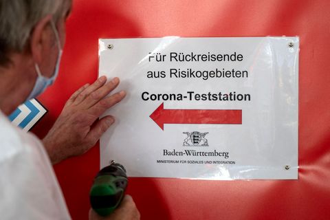  Ein Mitarbeiter des Sozialministeriums bringt im Hauptbahnhof Stuttgart Wegweiser zu einer Covid-19-Teststation für Rückreisende aus Risikogebieten an