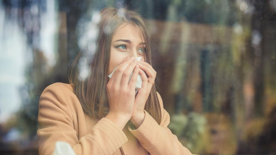 Erkältung Coronavirus: Eine Frau benutzt ein Taschentuch