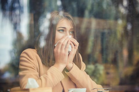 Erkältung Coronavirus: Eine Frau benutzt ein Taschentuch