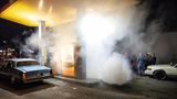 Eine Tankstelle gehüllt in den Rauch der Reifen