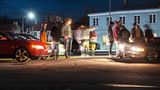 Zwei Autos leuchten eine Gruppe von Menschen an