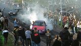 Autofahrer lassen, umring von Autofans, ihre Reifen durchdrehen