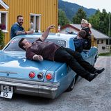 Ein Mann liegt quer auf einem Chevrolet