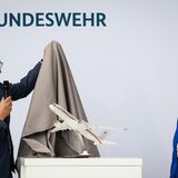 Beginn der Zeremonie: Der Vorstandsvorsitze der Lufthansa Technik, Johannes Bußmann, enthüllt zunächst ein Modell des neuen Airbus A350 in Anwesenheit von Annegret Kramp-Karrenbauer